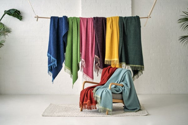 Group_of_hanging_wildweave_wool_blankets_in_blue_green_pink_purple_and_yellow_-_The_British_Blanket.jpeg