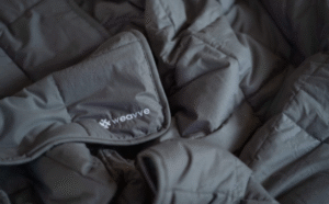 A_close_up_of_a_grey_weighted_blanket_with_the_Weavve_logo_a6175992-9e9b-48de-9d51-05cc0a85cce6_1200.png