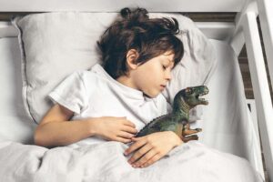 little-boy-sleeping-in-bed-hugging-his-dinosaur-to-2022-11-17-15-13-19-utc-1.jpg
