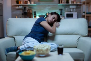 portrait_woman_sleeping_couch_living_front_television_tired_exhausted_lonely_sleepy_lady_pajamas_fal.webp