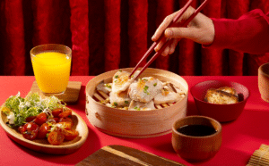 A_man_s_hands_picking_up_food_with_chopsticks_with_red_background_1200x1200.png
